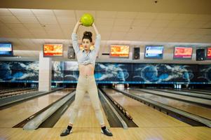 flicka med bowlingklot på gränden spelade på bowlingklubben. foto