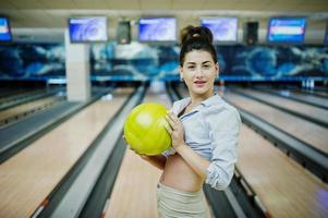 flicka med bowlingklot på gränden spelade på bowlingklubben. foto