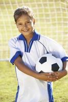 ung flicka klädd i fotbollsats stående vid mål foto