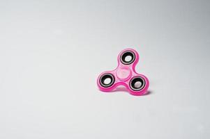 närbild av en rosa fidget spinner på en vit bakgrund. foto