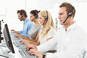 affärsmän med headset som använder datorer i office
