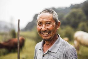 leende bonde med boskap i bakgrunden, lantliga porslin, shanxiprovinsen foto