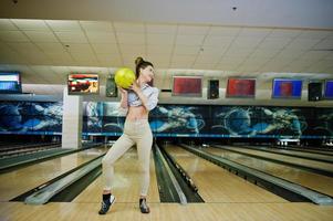 flicka med bowlingklot på gränden spelade på bowlingklubben. foto