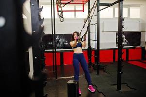 ung vacker kvinna gör övningar och arbetar hårt i gymmet och njuter av sin träningsprocess. foto