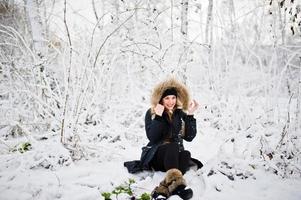 vacker brunett flicka i vinter varma kläder. modell på vinterjacka och svart mössa. foto