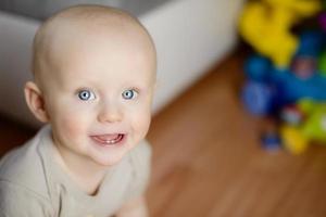 6 månaders baby som visar sina två första tänder skrattar foto