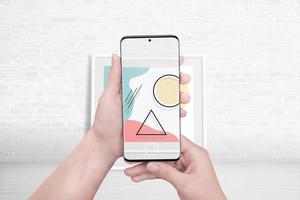 titta på en konstutställning med målningar genom ett appkoncept för augmented reality. kvinna med smart telefon och överlagra bild foto