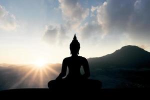 siluett av buddha vid solnedgången foto