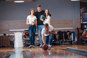 bild i rörelse. unga glada vänner har kul i bowlingklubben på sina helger foto