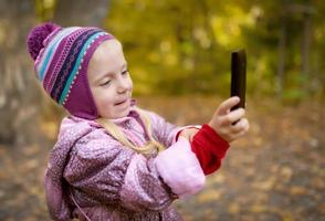 liten flicka att göra foto med smartphone.