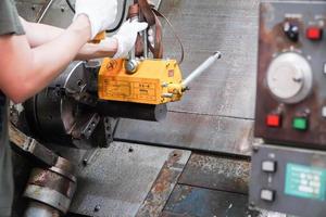 mekaniker använder en magnet för att lyfta arbetsstycket kontrollerat för hand. foto