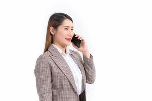 Asiatisk affärskvinna i formell kostym med vit skjorta ringer telefon och öppnar dokumentfil eller urklipp för att kontrollera data. foto