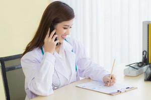 asiatiska professionella kvinnliga läkare ger telefonrådgivning. hälso-och skydd koncept. foto