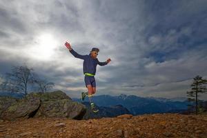 trail running idrottare hoppar mellan stenarna foto