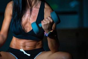muskulös kropp av brunett kvinna med gym vikt foto