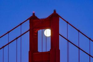 majestätiska san francisco golden gate bridge med fullmånen i juni 2022 och norra tornet sett från marin udde i Kalifornien foto