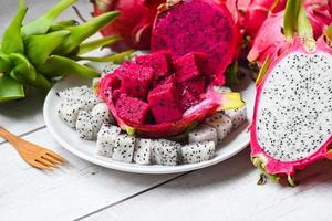 drak frukt skiva och skär hälften på vit platta med pitahaya bakgrund, färsk vit och röd lila drak frukt tropisk i det asiatiska thailand hälsosam frukt koncept foto