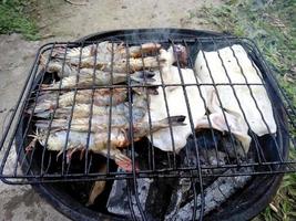 grillad bläckfisk och räkor på grillen. indonesisk kulinarisk mat foto