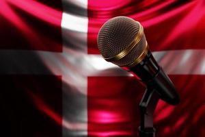 mikrofon på bakgrunden av Danmarks nationella flagga, realistisk 3d-illustration. musikpris, karaoke, radio och ljudutrustning för inspelningsstudio foto