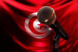 mikrofon på bakgrunden av den nationella flaggan i Tunisien, realistisk 3d-illustration. musikpris, karaoke, radio och ljudutrustning för inspelningsstudio foto