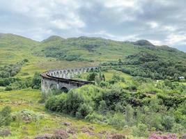 en vy av glenfinnanviadukten som visar ett ångtåg som passerar över den foto