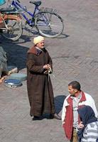 Marrakech, Marocko - 12 september 2018 - en man i traditionella kläder som håller sin husdjursorm på ett stadstorg i Marrakech, Marocko. foto