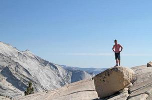 ung man som står på en sten framför en Yosemite bergskedja panorama foto