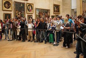 paris, frankrike - 12 september 2008 - en stor folkmassa utan smartphones av turister utan smartphones ställde upp vid barriären framför mona lisa i gallret för att ta en titt på målningen. foto