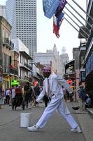 12 april 2018 - new orleans, louisiana, usa - gatukonstnär under sitt uppträdande i det franska kvarteret i new orleans, louisiana, med folkmassor och neonljus i bakgrunden. foto