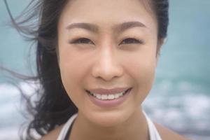 porträtt av vacker asiatisk kvinnlig turist vid havet, naturturismkoncept foto