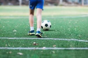 pojke står med boll på fotbollsplan redo att börja eller spela nytt spel - sport spelare koncept foto
