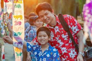 thailändsk familj deltar i gammal traditionell aktivitet i ett tempel under songkran-festivalen i chiang mai, norra thailand, mycket berömd händelse i thailand foto