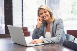 blond affärskvinna leende med laptop foto