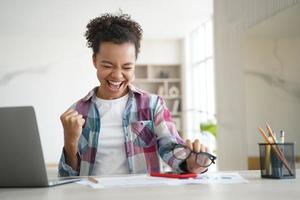 upprymd biracial flicka student firar seger, fick e-post med bra poäng. personlig framgång foto