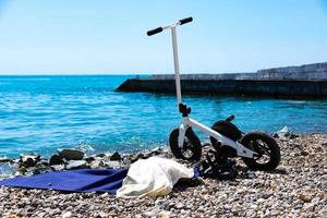 sportcykel i vitt, skotern står parkerad på stranden. selektiv fokusering. foto