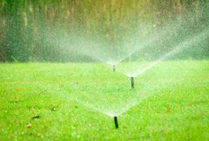 automatisk gräsmatta sprinkler vattning grönt gräs. sprinkler med automatiskt system. trädgård bevattningssystem vattning gräsmatta. vattenbesparing eller vattenbesparing från sprinklersystem med justerbart huvud. foto