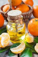 flaska essentiell citrusolja och mogna mandariner i korgen