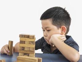 barn spelar jenga, ett träklossstornspel foto