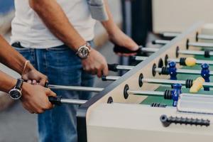 vänner spelar fotboll fotbollsmatch, är spelare. män spelar i kicker tillsammans som lag. fotbollsmatch. tävling och underhållning koncept foto