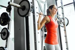 ung vacker kvinna lyfta vikter i ett gym