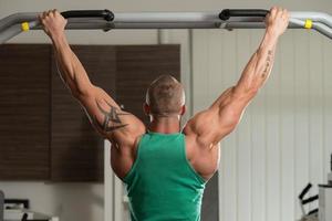 bodybuilder gör pull-ups bästa ryggövningar foto