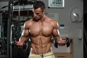 kroppsbyggare som utövar biceps med hantlar