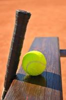 tennisracket och boll på bänken foto