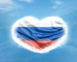 Ryssland flagga i hjärtform på blå himmel foto