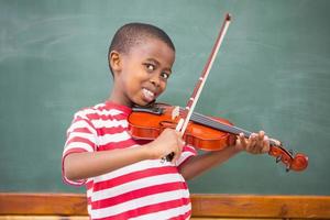 glad elev som spelar fiol i klassrummet