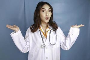 ett porträtt av en ung asiatisk kvinnlig läkare pekar på båda sidor kopia utrymme foto