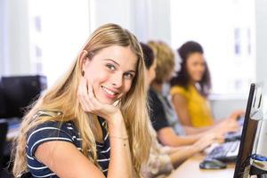 student som ler mot kameran i datorklass