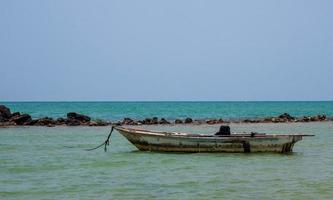 landskap se vy liten fiskebåt trä gammal parkerad kust havet. efter fiske av fiskare i liten by är det litet lokalt fiske. blå himmel, vita moln, klart väder, phala beach, rayong foto