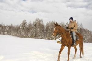 en tjej rider på en häst på vintern. jullov foto