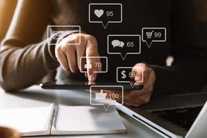 sociala medier och marknadsföring virtuella ikoner skärm concept.close up av affärskvinna att skriva tangentbord med laptop foto